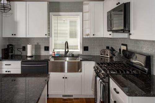 a kitchen with white cabinets and a sink and a stove at Queen Bed - Boston - RM 2 in Stoneham