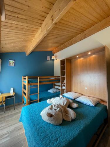 1 dormitorio con 2 literas y paredes azules en Gîte Du Puy de l'étang en Laruscade