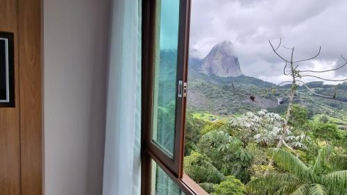a window with a view of a mountain at Loft 335 Vista Azul- De frente para a Pedra Azul in Pedra Azul