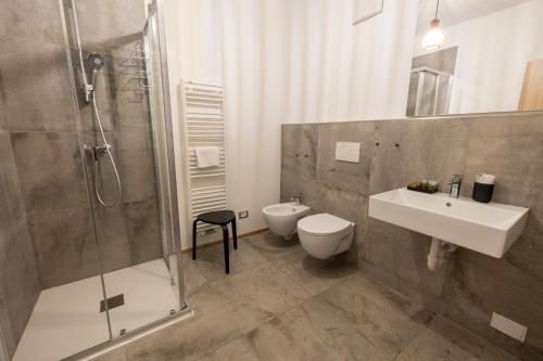 a bathroom with a shower and a sink and a toilet at Hotel Casa Alpina in Folgaria