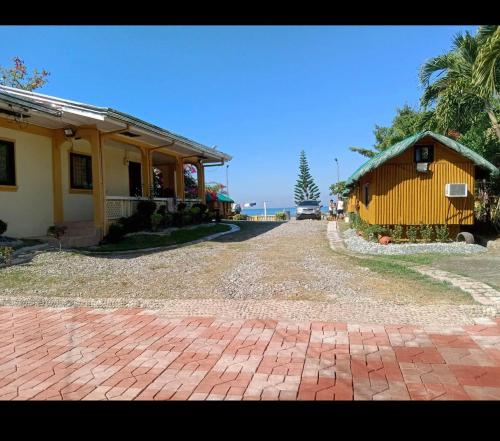 a house with a brick driveway next to a building at Sea Breeze Beachfront Home and Cottages in San Juan