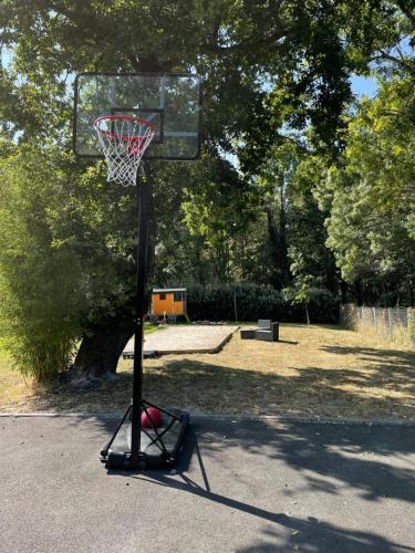 a basketball hoop with a basket in a park at Gîte Du Puy de l'étang in Laruscade
