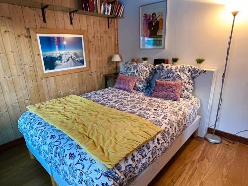 sypialnia z łóżkiem przykrytym żółtym kocem w obiekcie Appartement 2pieces Hyper Centre Les Houches, proche Chamonix w mieście Les Houches