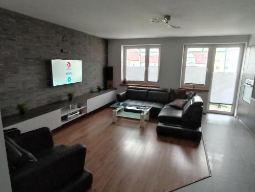 a living room with a couch and a tv at Apartament 24 dwie sypialnie in Płock