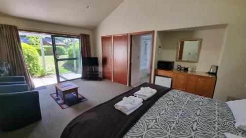 1 dormitorio con 1 cama grande y toallas. en 18 Jollies Pass Road - Garden Studio 346, en Hanmer Springs