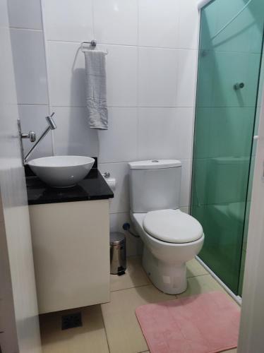 een badkamer met een toilet, een wastafel en een douche bij Lindo apto vista lateral do mar Itararé São Vicente in São Vicente