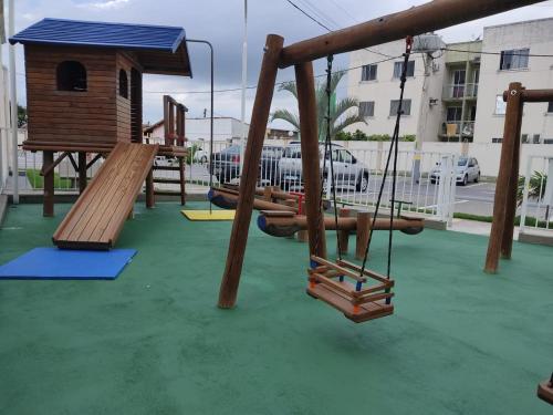 a playground with wooden swings and a bird house at Nosso Lar-Ap Rio das Ostras in Rio das Ostras