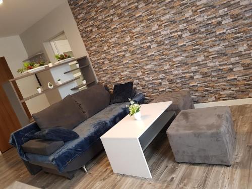a living room with a couch and a brick wall at Apartment DAISY, balcony, 5 os, Down Town in Kraków