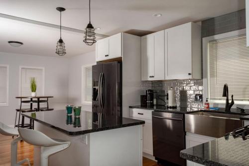 a kitchen with white cabinets and a stainless steel refrigerator at Queen Bed - Boston - RM 3 in Stoneham