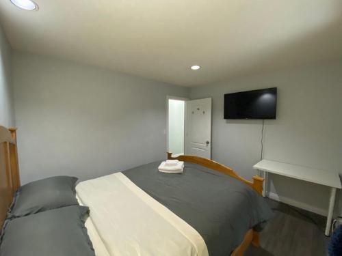 a bedroom with a bed and a tv on the wall at Anne's BNB in Surrey