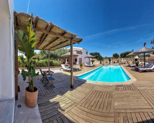a villa with a swimming pool and a wooden deck at Eco Finca Sa Font Blava in Llucmajor