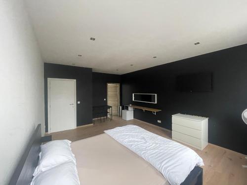 ein Schlafzimmer mit einem weißen Bett und einer schwarzen Wand in der Unterkunft Room of Tournai 3 in Tournai