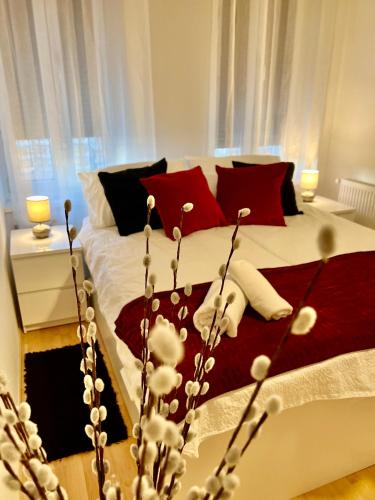um quarto com uma cama com almofadas brancas e vermelhas em The Downtown Pearl em Zagreb