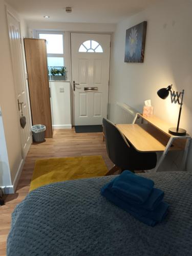 a bedroom with a bed and a desk and a door at The Annexe in Rothwell