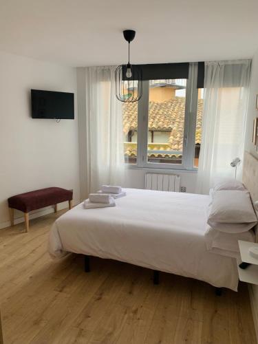 Un dormitorio con una gran cama blanca y una ventana en SAN LORENZO HUESCA con parking, en Huesca