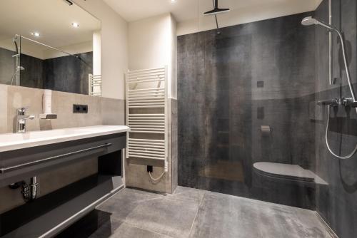 a bathroom with a sink and a shower and a toilet at Gästehaus Mirzl in Schladming