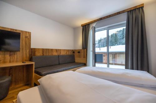 a hotel room with two beds and a window at Gästehaus Mirzl in Schladming