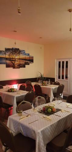 a dining room with tables and chairs with white table cloth at Forest Inn in Izvorani