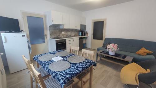 a living room with a table and a blue couch at Slunný byt v Jizerských horách 5 postelí in Tanvald