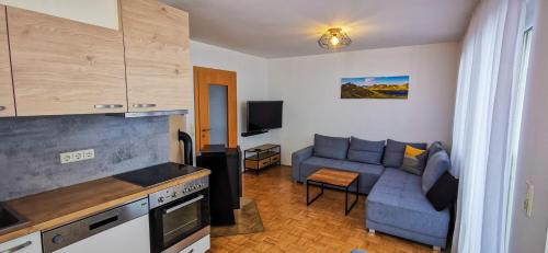 uma cozinha e uma sala de estar com um sofá em Apartments Bergblick em Sonnenalpe Nassfeld