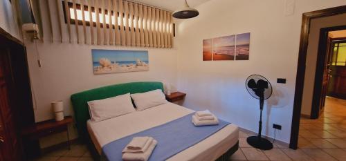 a small bedroom with a bed and a fan at Villa Santina - Cefalù in Cefalù