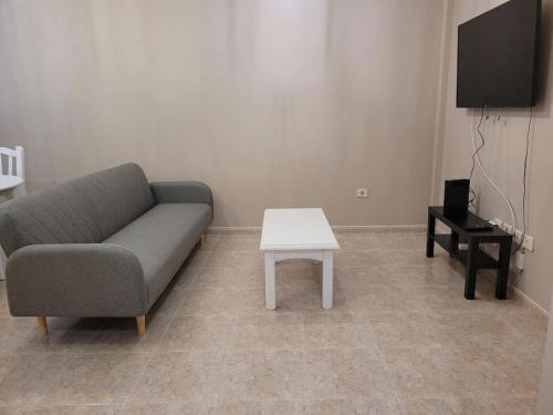 ein Wohnzimmer mit einem Sofa und einem Tisch in der Unterkunft casa/apto entero en morro jable in Morro del Jable