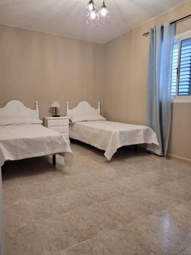 1 Schlafzimmer mit 2 Betten und einem Fenster in der Unterkunft casa/apto entero en morro jable in Morro del Jable
