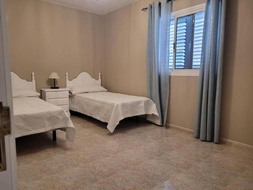 1 Schlafzimmer mit 2 Betten und einem Fenster in der Unterkunft casa/apto entero en morro jable in Morro del Jable