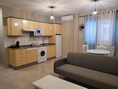 ein Wohnzimmer mit einem Sofa und einer Küche in der Unterkunft casa/apto entero en morro jable in Morro del Jable