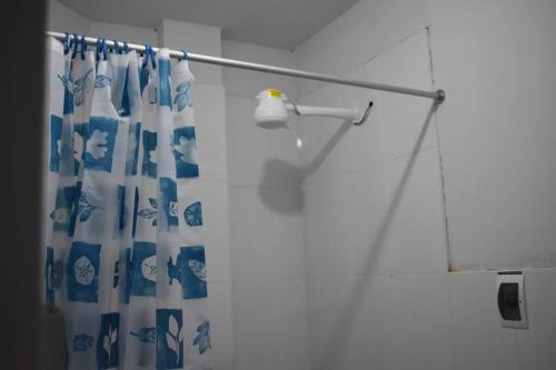 a shower with a blue and white shower curtain at Departamento-Parque y Flores M1 in Chiclayo