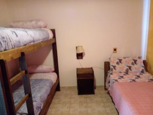 1 dormitorio con 2 literas y lámpara en Cabañas La Soñada en San Rafael