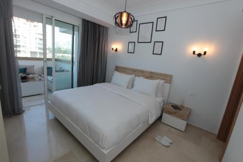 a bedroom with a large white bed and a window at Joumaya White & See in Casablanca