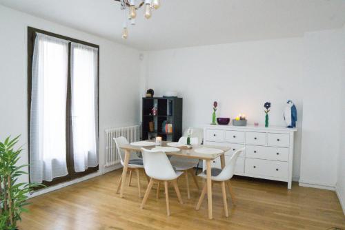 comedor con mesa y sillas blancas en EXIGEHOME-Grande maison aux portes de Paris, en Antony