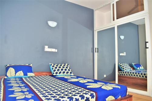 Habitación azul con cama con almohadas azules y blancas en RÉSIDENCE BELLEVUE SITO AIPORT- Lomé en Lomé
