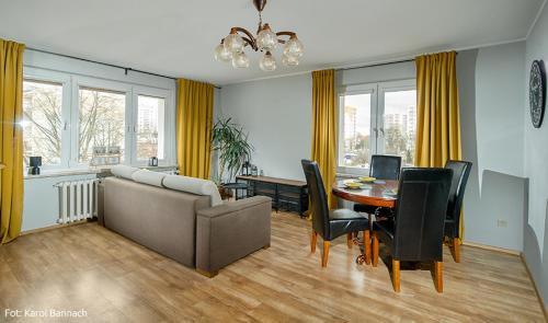 salon z kanapą i stołem z krzesłami w obiekcie Apartament na Traugutta w Elblągu