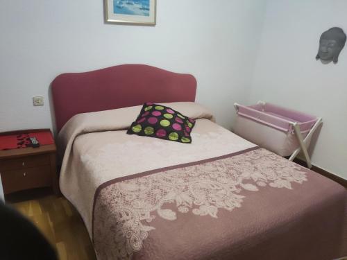 ein kleines Schlafzimmer mit einem Bett mit einem lila Kopfteil in der Unterkunft CHALET ADOSADO CON GARAGE Y TERRENO in Uruñuela
