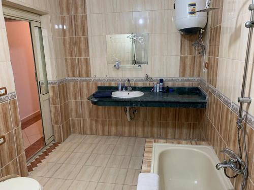 a bathroom with a bath tub and a sink at Schöne Wohnung mit Blick auf Nil und Pyramiden in Cairo