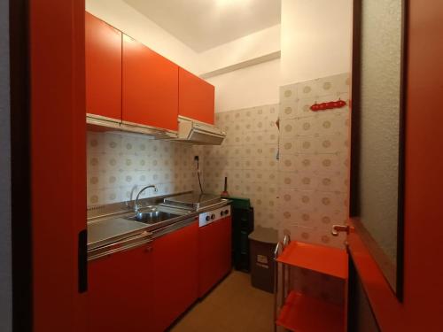 a small kitchen with red cabinets and a sink at Nic snow house in Roccaraso