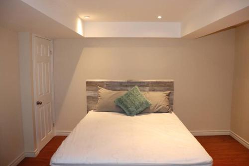 a bedroom with a white bed with a headboard at Entire 4 bed room detached residential home in Ajax