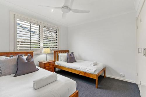 a bedroom with two beds and a window at Rayner's Secret in Lennox Head