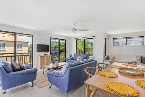 a living room with blue couches and a table at Rayner's Secret in Lennox Head