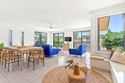 a living room with a table and blue chairs at Rayner's Secret in Lennox Head