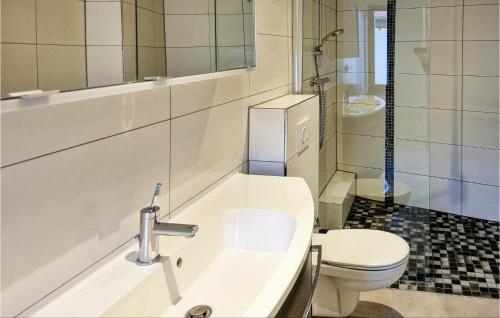 La salle de bains blanche est pourvue d'un lavabo et de toilettes. dans l'établissement 2 Bedroom Cozy Apartment In Kltze, à Klötze