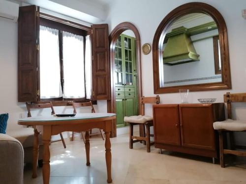 een woonkamer met een tafel en een spiegel bij Casa Rural Torre del Agua. Un lugar con encanto. in Osuna
