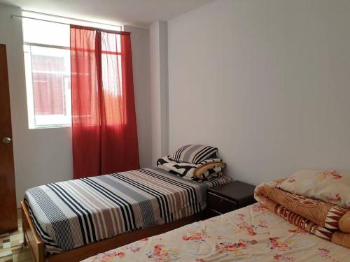 1 dormitorio con 2 camas y ventana en Departamento-Mamá Feli M5, en Chiclayo