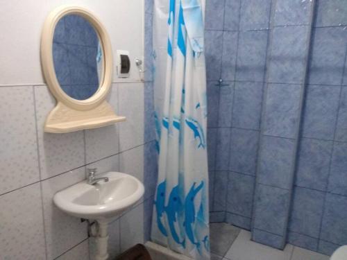 y baño con lavabo y ducha con espejo. en Departamento-Mamá Feli M5, en Chiclayo