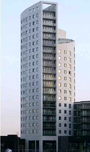 Un grand bâtiment blanc avec de nombreuses fenêtres dans l'établissement Leeds Dock Apartment, à Hunslet