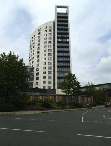 um grande edifício com um parque de estacionamento em frente em Leeds Dock Apartment em Hunslet