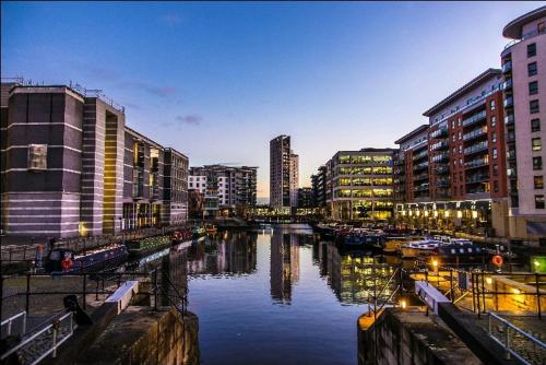 uma cidade com edifícios e um rio com barcos em Leeds Dock Apartment em Hunslet