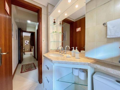 y baño con lavabo y espejo. en Apartamentos Condado Di Positano no CENTRO by Achei Gramado, en Gramado